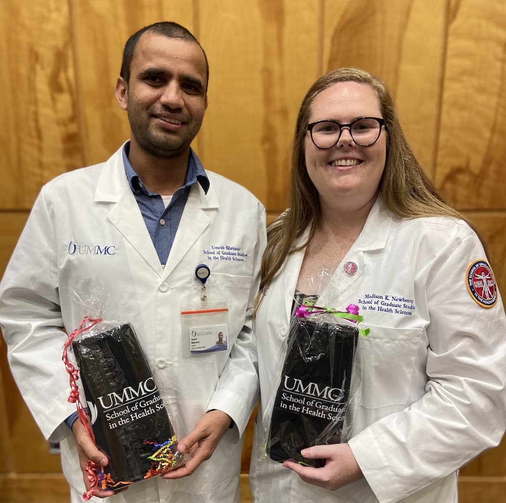 Umesh Bhattari and Madison Newberry smiling while holding awards.